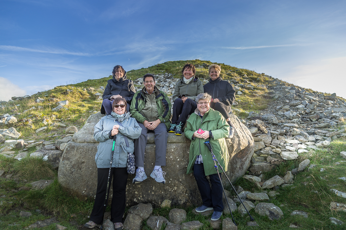 Guests seated in the "hag's chair" at Loughcrew - Hill of the Hag